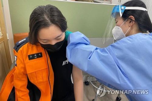 In this photo provided by Daegu Fire Service, a firefighter receives an AstraZeneca vaccine shot on March 8, 2021, when 344 new cases, including 11 from abroad, were reported. (Yonhap)