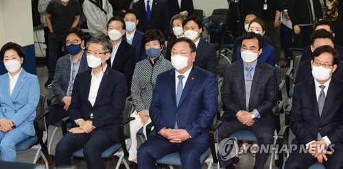 Kim Tae-nyeon (C), acting chairman of the ruling Democratic Party, looks grim on April 7, 2021, as he watches the exit poll of the Seoul and Busan mayoral by-elections on TV at the party's headquarters in Seoul. (Yonhap)
