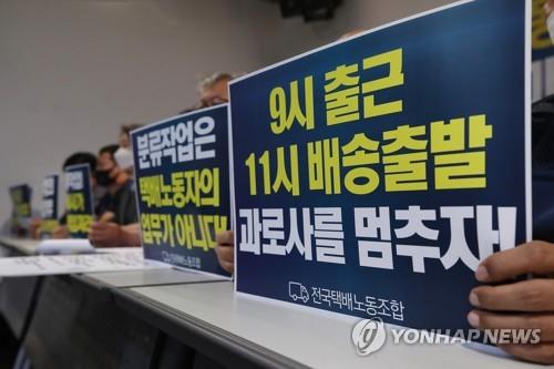 This file photo shows officials from the Parcel Delivery Workers' Solidarity Union holding signs announcing their planned collective action during a news conference held in central Seoul on June 4, 2021. (Yonhap)