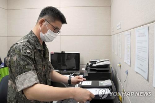 This photo, provided by the defense ministry on July 27, 2021, shows a South Korean service member sending a fax message to North Korea via the inter-Korean western military communication line. (PHOTO NOT FOR SALE) (Yonhap)