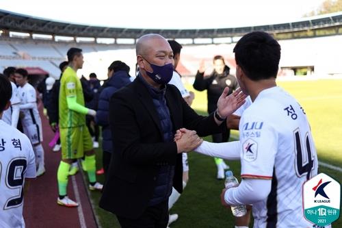 Gimcheon Sangmu head coach Kim Tae-wan (L) shakes hands with his player Jung Dong-yoon after Gimcheon's 1-0 victory over Bucheon FC in the clubs' K League 2 match at Bucheon Stadium in Bucheon, Gyeonggi Province, on Oct. 17, 2021, in this photo provided by the Korea Professional Football League. (PHOTO NOT FOR SALE) (Yonhap)