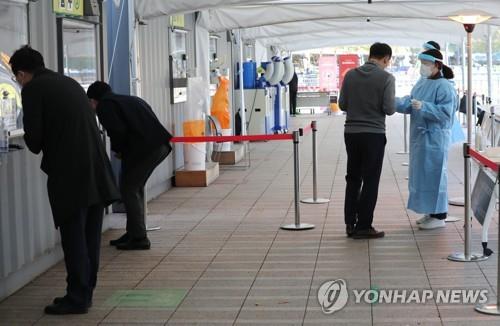 People take coronavirus tests at a clinic in front of City Hall in Seoul on Oct. 20, 2021. (Yonhap)