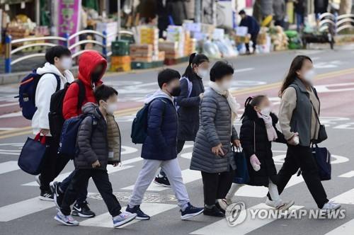 Students head to in-person classes at an elementary school in Seoul's Yongsan district on the first day of the full resumption of in-person school attendance on Nov. 22, 2021. (Yonhap)