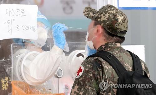 In this May 24, 2021, file photo, a soldier receives a COVID-19 test at a makeshift clinic in central Seoul. (Yonhap)