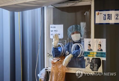 A health worker prepares for COVID-19 tests at a makeshift testing station in Seoul on Jan. 16, 2022. (Yonhap)