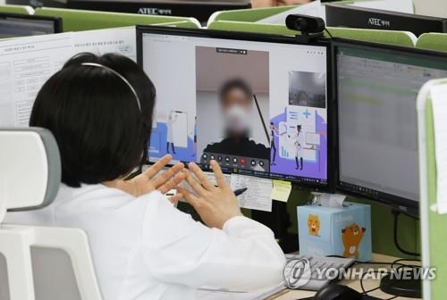 A medical worker talks to a coronavirus-infected patient via video link at a medical facility in Seongnam, near Seoul, on Jan. 21, 2022, as the patient is being treated at home with Paxlovid, COVID-19 treatment pills developed by U.S. pharmaceutical giant Pfizer Inc. (Pool photo) (Yonhap)