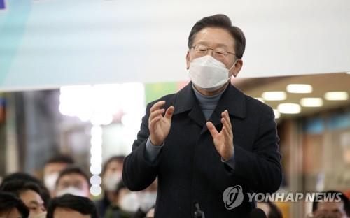 Lee Jae-myung, the presidential candidate of the ruling Democratic Party, gives an impromptu speech at a traditional market in Seongnam, south of Seoul, on Jan. 24, 2022. (Pool photo) (Yonhap)