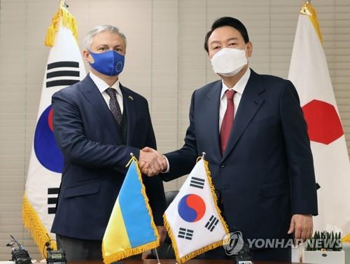 Presidential candidate Yoon Suk-yeol (R) of the main opposition People Power Party and Ukrainian Ambassador-designate to South Korea Dmytro Ponomarenko pose before a meeting in Seoul on March 2, 2022. (Pool photo) (Yonhap)