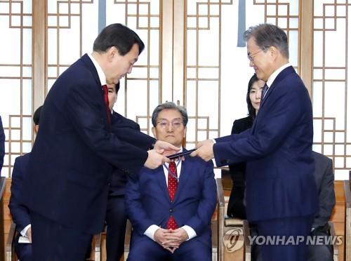 This file photo, taken July 25, 2019, shows President Moon Jae-in (R) presenting new Prosecutor General Yoon Suk-yeol with a letter of appointment at the presidential office Cheong Wa Dae. Yoon, the presidential candidate of the main opposition People Power Party, who won South Korea's presidential election on March 10, 2022, is set to take office on May 10 and serve a single five-year term. (Yonhap)