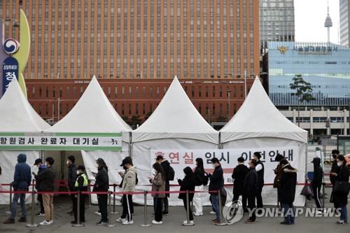 People line up to take COVID-19 tests at a makeshift testing station in Seoul on March 31, 2022. (Yonhap)