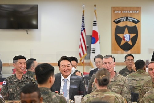 President-elect Yoon Suk-yeol (2nd from L) laughs while sharing a meal with South Korean and U.S. troops at Camp Humphreys in Pyeongtaek, 70 kilometers south of Seoul, on April 7, 2022, in this photo provided by his office. (Yonhap)