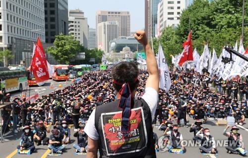 Unionized truck drivers affiliated with the Korean Confederation of Trade Unions chant slogans during a rally on a road in central Seoul, in this May 28, 2022, file photo. They declared they would begin an indefinite general strike June 7, demanding raises in cargo transportation fares to reflect recent hikes in diesel prices, among others. (Yonhap)