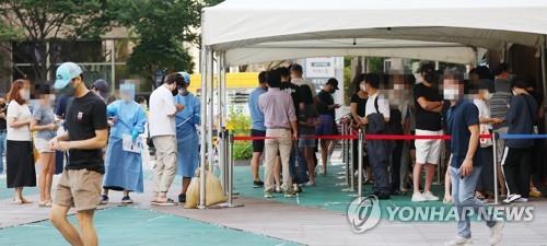 People line up to undergo COVID-19 tests at a makeshift testing station in Seoul on Aug. 16, 2022. (Yonhap)