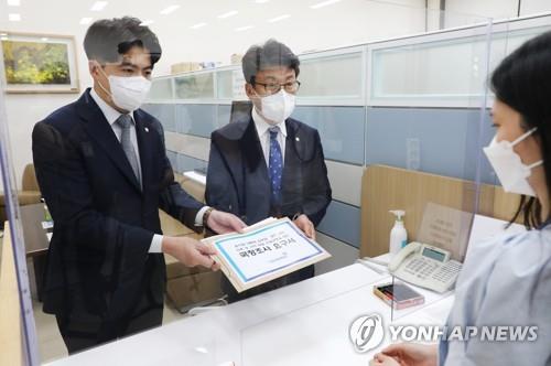 The main opposition Democratic Party's vice floor leader Jin Sung-joon (R) and spokesperson Oh Yeong-hwan submit a request to launch a parliamentary probe into alleged irregularities involving the presidential office to the National Assembly in western Seoul on Aug. 17, 2022. (Pool photo) (Yonhap)