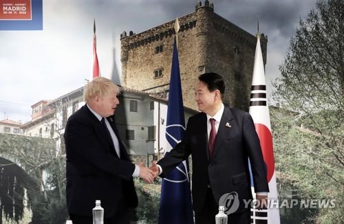 South Korean President Yoon Suk-yeol (R) shakes hands with British Prime Minister Boris Johnson prior to their talks at the IFEMA Convention Center in Madrid on June 30, 2022, on the sidelines of a summit of the North Atlantic Treaty Organization. (Yonhap)