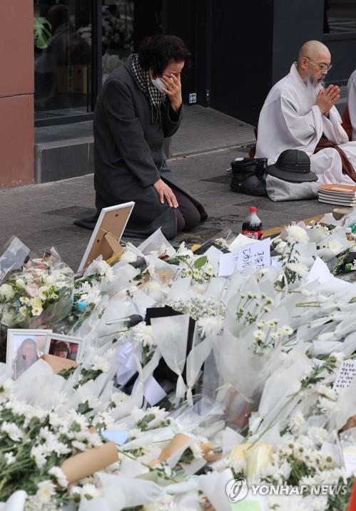 A mourner sheds tears at a makeshift memorial in front of a subway station in Seoul's Itaewon district on Nov. 3, 2022, set up in honor of the victims of a crowd crush on Oct. 29. (Yonhap) 