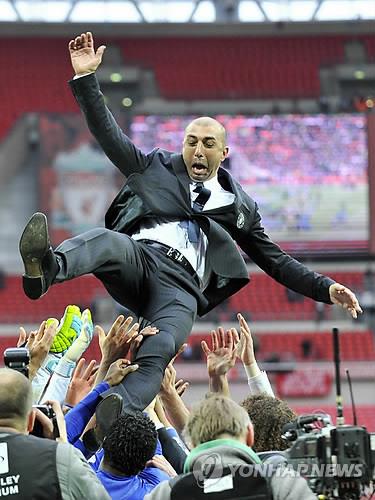 In this EPA file photo from May 5, 2012, Chelsea players toss their manager Roberto Di Matteo in the air after beating Liverpool 2-1 in the FA Cup final at Wembley Stadium in London. (Yonhap)