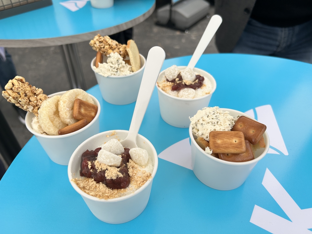 This photo shows cups of special "bingsu," a traditional Korean ice dessert, made with plant-based milk (on the bottom), and "ppeongtwigi," puffy rice crackers (on the top), served with cream cheese made with non-animal proteins. These sustainable food products will be served at a food truck run by SK outside the main exhibition hall at CES, due to take place in Las Vegas from Jan. 5-8, 2023. (Yonhap) 