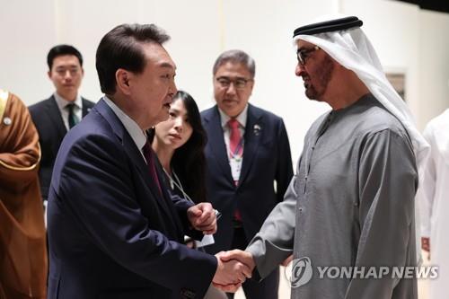 President Yoon Suk Yeol (L) shakes hands with United Arab Emirates President Mohamed bin Zayed Al Nahyan during the opening ceremony of Abu Dhabi Sustainability Week at the Abu Dhabi National Exhibition Centre in the capital of the UAE on Jan. 16, 2023. (Yonhap)