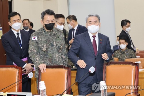 Defense Minister Lee Jong-sup (R) and Joint Chiefs of Staff Chairman Gen. Kim Seung-kyum (2nd from L) take their seats at the National Assembly in western Seoul on Jan. 26, 2023, before they report to lawmakers on the military's weekslong inspection of the operation against five North Korean drones that violated the South's airspace on Dec. 26. (Yonhap)