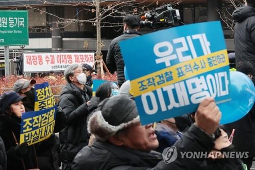 Supporters of Democratic Party Chair Lee Jae-myung hold up placards denouncing a prosecution probe of him in front of the Seoul Central District Prosecutors Office on Feb. 10, 2023. (Yonhap)