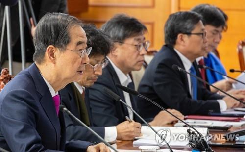 Prime Minister Han Duck-soo (L) speaks while presiding over a government meeting at the government complex in Seoul on April 12, 2023, to discuss combating school violence. (Yonhap)