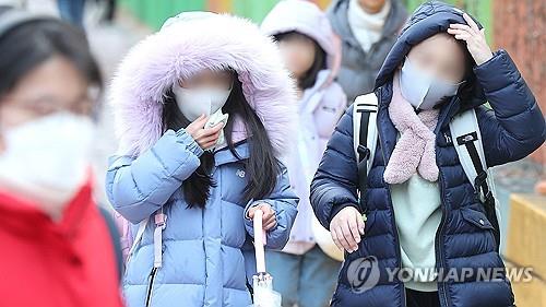 Estudiantes de primaria vestidos con abrigos gruesos y ropa de invierno van a la escuela en la ciudad sudoriental de Daegu el 20 de diciembre de 2023. (Yonhap)