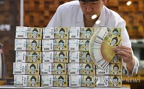 사진 속 한 관계자가 2023년 9월 25일 서울 하나은행 본점에서 5만원권 위조 여부를 확인하고 있다.(연합)