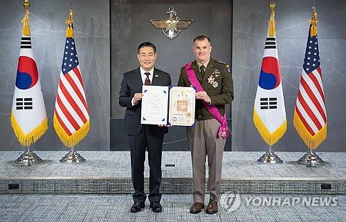 Gen. Charles A. Flynn (R), commander of the U.S. Army Pacific, and Defense Minister Shin Won-sik pose for a photo after Flynn received a state medal from the South Korean government for his contributions to the bilateral alliance at the defense ministry's headquarters in central Seoul on April 4, 2024, in this photo provided by the defense ministry. (PHOTO NOT FOR SALE) (Yonhap)