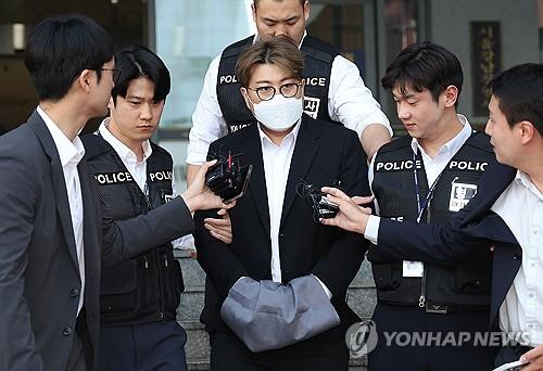 Trot singer Kim Ho-joong (C) answers questions from reporters before leaving the Seoul Gangnam Police Station in the capital city on May 31, 2024. (Yonhap)
