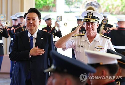 President Yoon Suk Yeol (L) and Adm. Samuel Paparo, commander of the Indo-Pacific Command, salute their countries' national flags during Yoon's visit to Camp Smith, the command's headquarters in Hawaii, on July 9, 2024. (Yonhap)