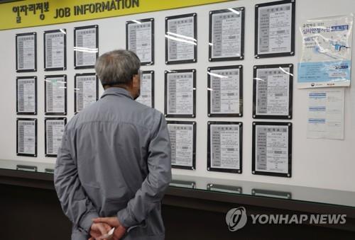 Un hombre revisa las ofertas de trabajo en un centro de empleo en Seúl el 17 de abril de 2023. (Yonhap)