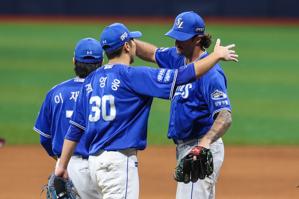 Samsung Lions starter Connor Seabold (R) celebrates with his third baseman, Kim Young-woong, after throwing a complete game shutout against the Kiwoom Heroes in the teams' Korea Baseball Organization regular-season game at Gocheok Sky Dome in Seoul on Aug. 27, 2024, in this photo provided by the Lions. (PHOTO NOT FOR SALE) (Yonhap)