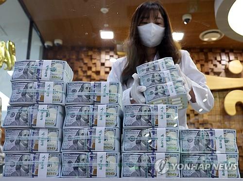 A banker checks dollars at KEB Hana Bank's Counterfeit Notes Response Center in Seoul, in this file photo taken July 3, 2024. (Yonhap)