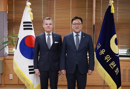 Financial Services Commission (FSC) chief Kim Byoung-hwan (R) poses for a photo with Jacek Jastrzebski, the head of Poland's financial watchdog, KNF, after signing a memorandum of understanding on financial cooperation in Seoul on Nov. 13, 2024, in this photo provided by the FSC. (NOT FOR SALE) (Yonhap)