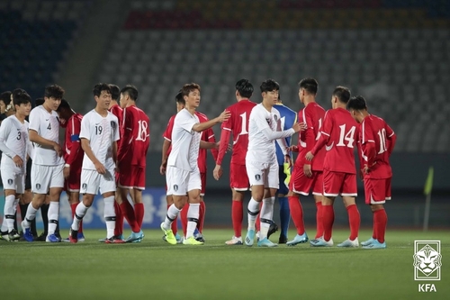 Des joueurs des équipes nationales de football de la Corée du Sud (en blanc) et de la Corée du Nord (en rouge) se saluent après un match nul au stade Kim Il-sung à Pyongyang, le 15 octobre 2019, dans le cadre des qualifications Asie pour la Coupe du monde Qatar 2022. (Photo fournie par l'AFC. Revente et archivage interdits)