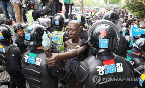 徴用工像を囲む警察＝１日、釜山（聯合ニュース）