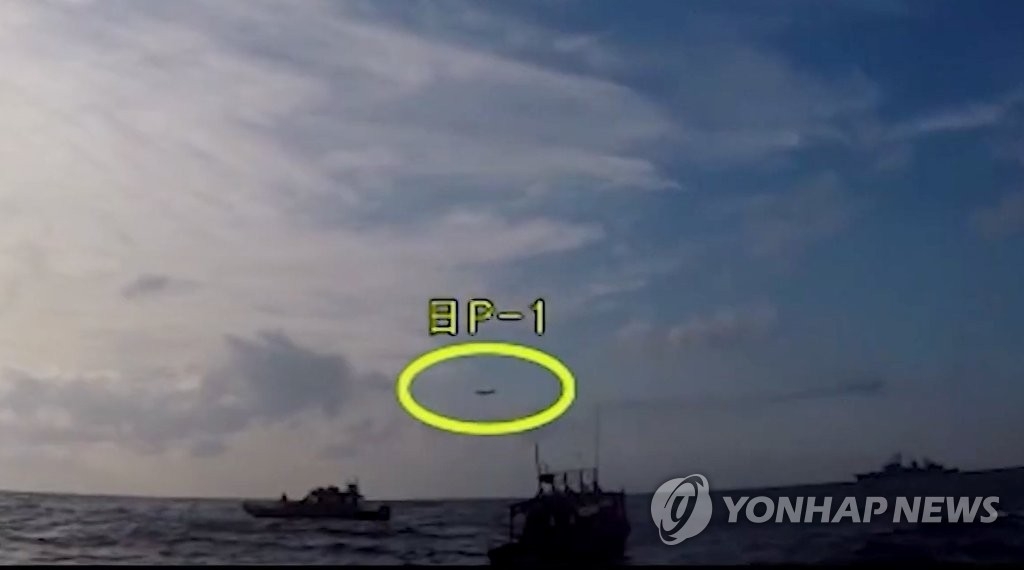 遭難した漁船を救助する韓国の艦艇の上空を日本の哨戒機（黄色の丸）が低高度で飛行する様子を韓国海洋警察が撮影した（国防部ユーチューブより）＝４日、ソウル（聯合ニュース）
