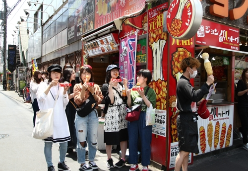 東京・新大久保で韓国式のホットドックを食べる日本の若者たち＝（聯合ニュース）