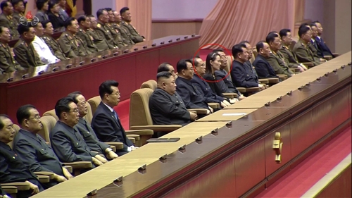８日、金日成主席の追悼大会に出席した金委員長（前列左から６人目）。金委員長から右に４人目の赤丸が与正氏で、金委員長の左右に座る８人が序列９位内とみられる＝（朝鮮中央テレビ＝聯合ニュース）