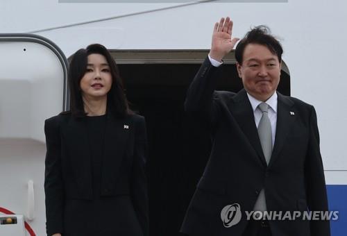 ソウル空港で大統領専用機の空軍１号機に乗り込む前、関係者らにあいさつする尹大統領夫妻＝１８日、城南（聯合ニュース）