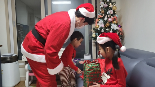 サンタクロースに扮して恵まれない子どもたちにプレゼントを届けるボランティア＝（聯合ニュース）