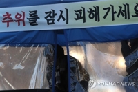 피하고 싶은 추위(광주=연합뉴스) 정회성 기자 = 광주와 전남 지역에 한파주의보가 내려진 24일 오전 광주 서구 치평동 한 버스정류장에서 시민이 바람막이용 온기텐트에 들어가 추위를 녹이고 있다. 2018.1.24 hs@yna.co.kr(끝) 