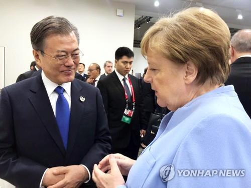 2019년 일본 오사카에서 열린 G20 정상회의에서 대화하는 문재인(왼쪽) 대통령과 메르켈 총리 [연합뉴스 자료사진]