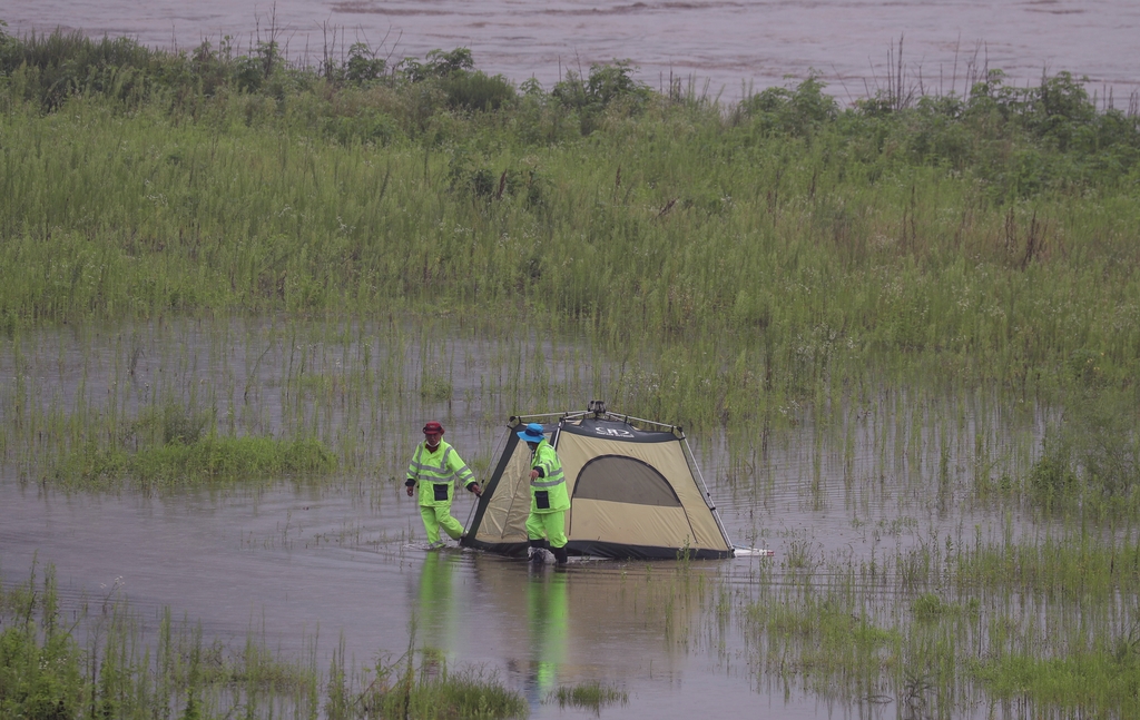호우로 물이 불어난 임진강변 텐트 정리하는 안전요원.