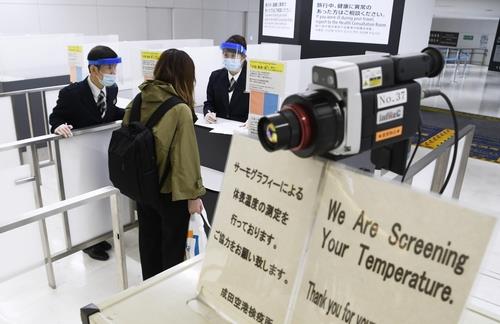 2020년 3월 26일 오후 신종 코로나바이러스 감염증(코로나19)이 확산한 가운데 일본 수도권 관문인 나리타(成田)공항에 도착한 여행자가 검역관으로부터 질문을 받고 있다. [교도=연합뉴스 자료사진]