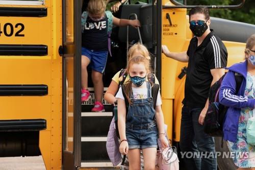 마스크를 쓰고 학교 버스에서 하차하는 캐나다 학생 [로이터=연합뉴스]