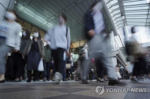 (도쿄 AP=연합뉴스) 20일 도쿄의 한 역에서 직장인들이 마스크를 쓰고 이동하고 있다.