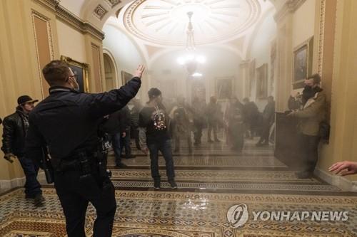연기 자욱한 의사당 안에서 경찰과 대치한 트럼프 지지자들
