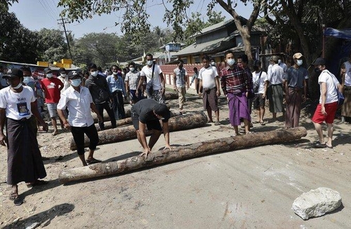 경찰이 시민 불복종 운동에 참여 중인 철도 근로자들의 업무 복귀를 강제하기 위해 진입을 시도하자 나무 둥치나 돌로 입구 도로를 막는 주민들. 2021.2.14[,EPA=연합뉴스]